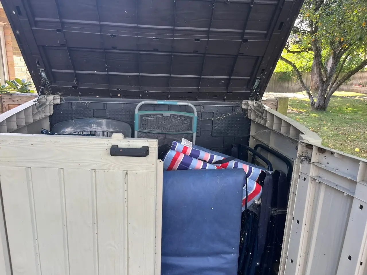 Garden storage box full of chairs and cushions