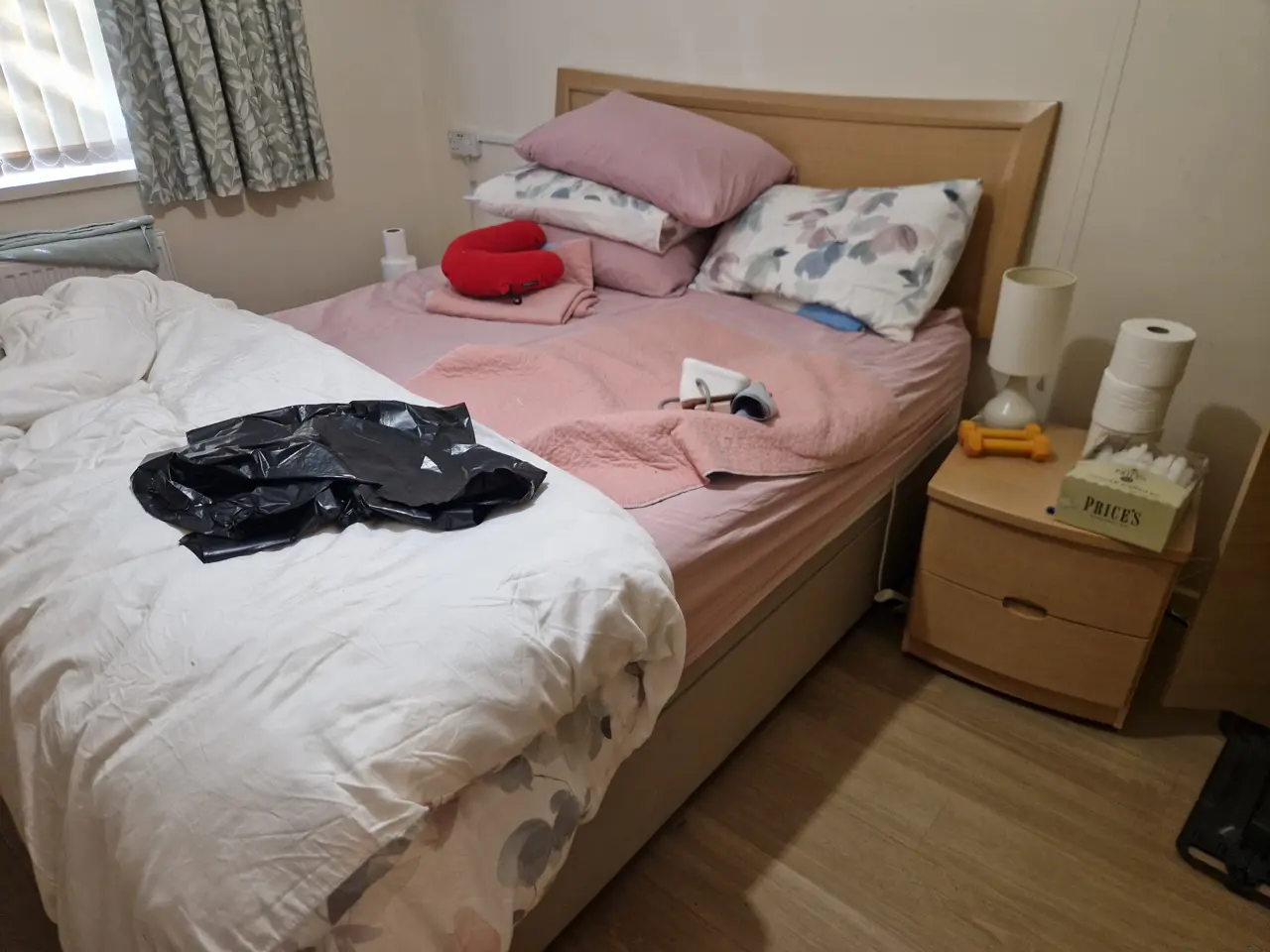 Bedroom before clearance — bed, bedding and bedside cabinet